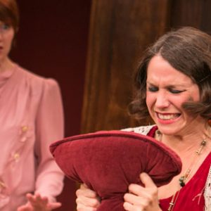 women squeezing pillow in anger