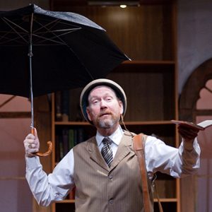 man holding an umbrella and a book