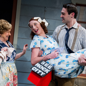 man carrying woman with red birdhouse