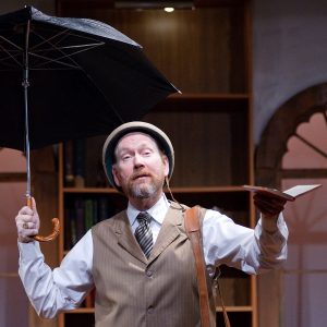 man holding an umbrella and a book